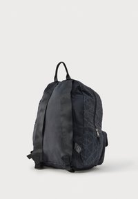 Mochila negra de nylon con correas acolchadas para los hombros, cierre con cremallera y un patrón geométrico sutil. Cuenta con una asa superior y un bolsillo lateral.