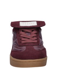 Bordeaux leren en suède sneaker met een gewatteerde tong, ronde veters en een lichtbruine rubberen zool. Bevat een merketiket op de tong.