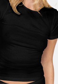 Black fitted t-shirt in soft, smooth fabric. Short sleeves, crew neckline, and a seamless design without visible stitching.