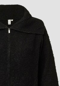 Czarna kurtka zapinana na zamek wykonana z teksturowanej tkaniny, z szerokim kołnierzem i srebrnym detalem zamka. Prosty design bez widocznych wzorów.