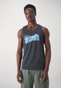 Svart bomullstopp med en fargerik "Hilsener fra Levi's" grafikk. Klassisk passform med rund hals og glatt tekstur.