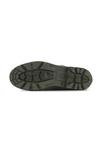 Suela de zapato outdoor en goma de color verde oscuro. Presenta patrones de tracción profundos, bordes curvados y áreas reforzadas para mayor durabilidad.