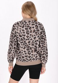 Leichte Bomberjacke mit Muster in braunem und schwarzem Leopardenprint, ausgestattet mit einem beigefarbenen, gerippten Kragen und Bündchen.