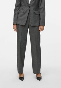 Grå skreddersydd dressjakke med matchende grå bukser. Teksturert stoff, hakkede slag og smal passform. Minimalistisk design med subtile detaljer.