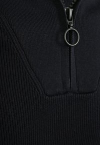 Marine blauwe ritstrui met ribbeltextuur, hoge kraag en een ronde rits-sleutel. De stof is zacht en slim-fit.
