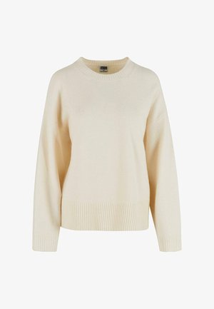 Pull en crème en tissu doux, avec un ourlet et des poignets côtelés, un col rond et une coupe décontractée avec des épaules tombantes.