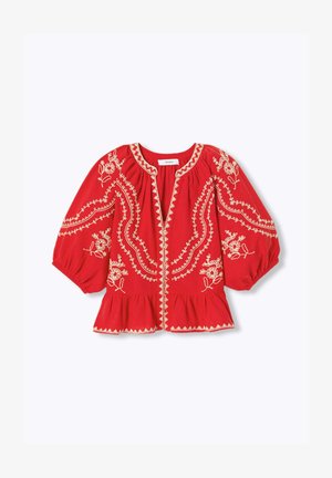 Blouse rouge avec broderie florale crème, manches trois-quarts bouffantes, encolure froncée et ourlet à volants.
