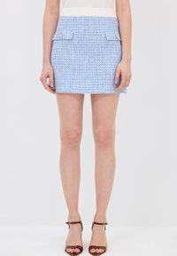 Vaaleansininen tweed-minihame, jossa on teksturoitu kuvio, kaksi etutaskua metallipainikkeilla ja muotoiltu vyötärösuunnittelu.