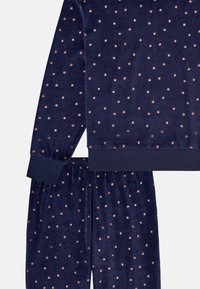 Navy blue pajama set made of soft fabric, featuring a star pattern in rose gold. Includes long-sleeve top and elastic waistband pants.