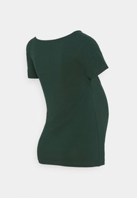 Tumma vihreä äitiys T-paito, jossa on lyhyet hihat ja pyöreä pääntie. Pehmeä kangas, hieman kaareva muotoilu kasvavan vatsan mukauttamiseksi.