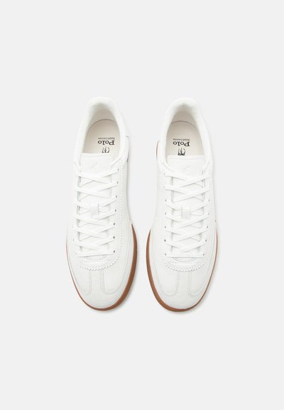 Ζευγάρι λευκά δερμάτινα αθλητικά παπούτσια Polo Ralph Lauren με λευκά κορδόνια και καφέ λαστιχένιες σόλες, σε θέαση από πάνω σε λευκό φόντο.