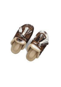 Bruine en witte bontslippers met een zachte beige voering, uitgerust met decoratieve franjes en een platte zool. Textuur aan de buitenkant met een comfortabele constructie.