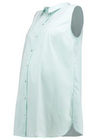 Chemisier de maternité bleu clair sans manches avec boutons sur le devant et col, conçu pour accueillir un ventre de femme enceinte.