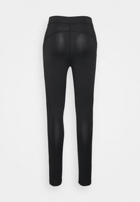 Leggings pretos com um cós alto, textura suave e design ajustado. Costuras notáveis na parte de trás e forma da perna afunilada.