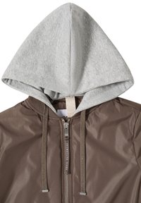 Veste marron zippée avec capuche en tissu gris clair et cordons marron assortis, ornée de détails en texte en relief.