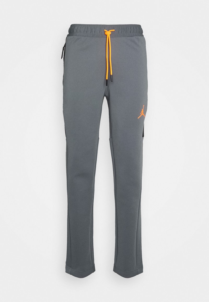 Grå sweatpants i mjukt tyg, med resårmidja och orange snoddar samt en orange logotyp på vänstra låret.