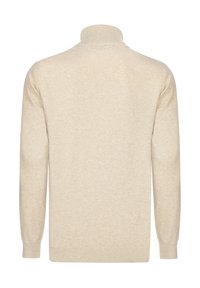 Beige sviiter kõrge kraega, soonikŭlgedega ja hemiga, valmistatud pehmest, tekstureeritud kangast, millel on sile ja ühtlane kudumine.