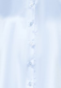 Tissu de chemise bleu clair avec une rangée verticale de cinq boutons blancs au centre devant.