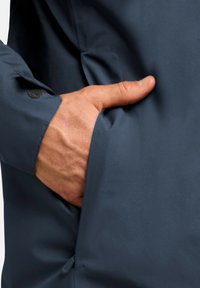 Marine waterdichte jas met een gestructureerd oppervlak, voorzien van een zijzak en een beveiligde manchet sluiting. Hand geplaatst binnen in de zak.