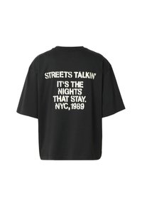 Μαύρο oversized T-shirt με λευκό κείμενο που γράφει "STREETS TALKIN’ IT’S THE NIGHTS THAT STAY. NYC, 1989" στην πλάτη.