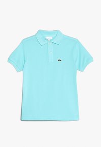 Jasnoniebieska koszulka polo z krótkim rękawem, z dwoma guzikami i małym zielonym logo krokodyla na piersi.