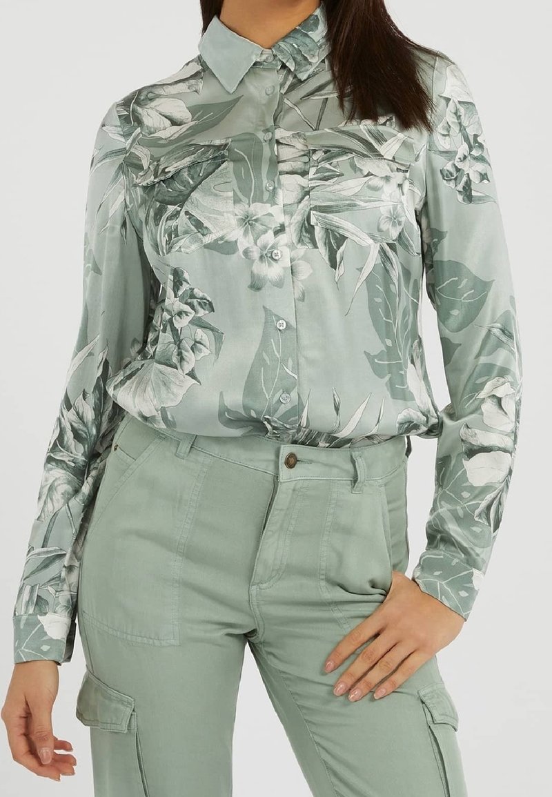 Hellgrünes, blumiges Kurzarmhemd mit Kragen, das ein tropisches Design aufweist, kombiniert mit passenden hellgrünen Cargo-Hosen.