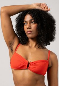 Rode bikini-top met een gedraaide voorkant, verstelbare bandjes en accenten van zilver hardware. Glad stoftextuur en aansluitende pasvorm.