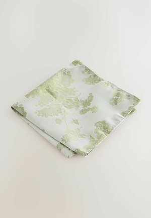 Floral patterned napkin in pale green and white, made of soft fabric, featuring raised embroidery with detailed botanical designs.