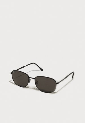 Óculos de sol de metal preto com armações ovais, lentes escuras, hastes finas e um logótipo discreto na lente esquerda. Design elegante e minimalista.