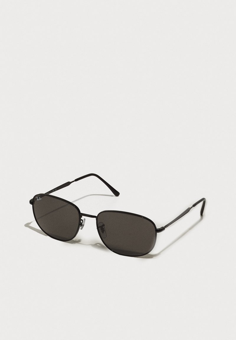 Ochelari de soare de metal negri cu rame ovale, lentile închise la culoare, brațe subțiri și un logo discret pe lentila stângă. Design elegant, minimal.