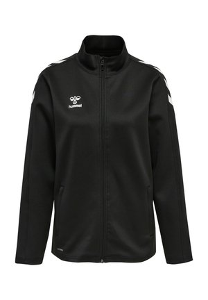 Black zip-up jacket made of soft fabric, featuring a high collar, side pockets, and white chevron accents on the shoulders. Hummel logo displayed.
