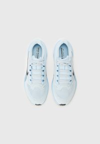 Baskets de course bleu clair avec une tige en mesh, un swoosh noir et des lacets blancs. Semelle texturée et languette rembourrée pour le confort et le soutien.