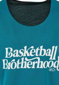 Teal mesh-basketball-paita mustalla kauluksella, jossa on valkoista tekstiä, joka lukee "Koripallo-veljeys" etupuolella.