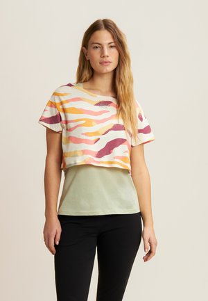 T-shirt cropped con motivo a onde multicolore in rosa, giallo e viola. Presenta uno strato di base verde chiaro e una vestibilità comoda.