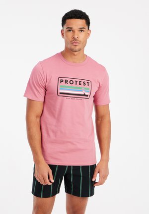 Rosa bomulds T-shirt med et rektangulært sort grafik med "PROTEST" og vandrette striber i blå, grøn og pink. Sæt sammen med sorte stribede shorts.
