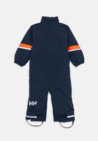 Mornarsko modr potni kombinezon s svetlo oranžnimi in belimi odsevnimi črtnimi na rokavih, elastičnimi manšetami, zaponkami na gležnjih in HH logotipom na nogi.