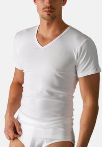 Weißes V-Ausschnitt-T-Shirt aus weicher Baumwolle. Kurze Ärmel, figurbetontes Design, glatter Stoff, mit leichtem Stretch und minimaler Markenkennzeichnung am Ärmel.