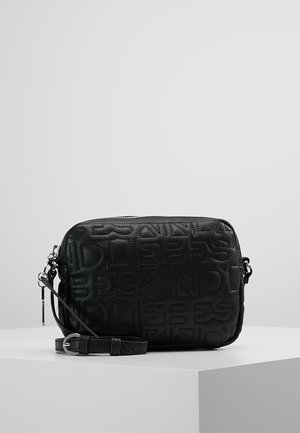 Musta nahkainen olkalaukku, jossa on kohokuvioitu abstrakti kirjainkuvio ja säädettävä olkahihna, asetettuna valkoiselle jalustalle harmaata taustaa vasten.