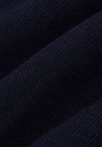 Granatowa dzianina, charakteryzująca się teksturowaną i miękką powierzchnią o delikatnym splocie oraz subtelnymi różnicami w odcieniu.