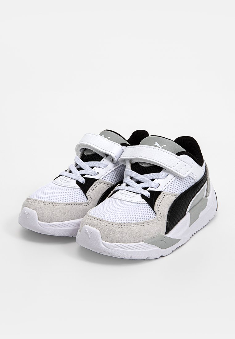 Witte en grijze sportschoenen met een zwarte accent. Bevatten elementen van gaas en suède, een klittenbandsluiting en een rubberen zool met textuurdetails.