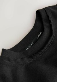 Must musta T-särk ümara kaeluse ja kulunud servaga. Siseosas on silt, millel on valgete tähtedega kirjutatud "ALLSAINTS".