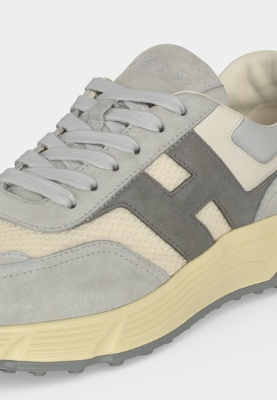 Baskets gris clair et crème avec des panneaux en daim, tissu mesh, logo gris "H", col rembourré et semelle en caoutchouc crème.