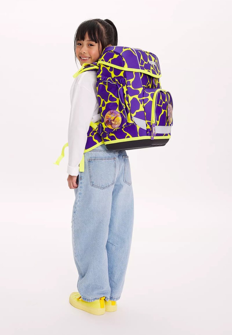 Zaino a motivo viola e giallo neon con più scomparti, spallacci regolabili e dettagli grafici circolari, indossato da un bambino.
