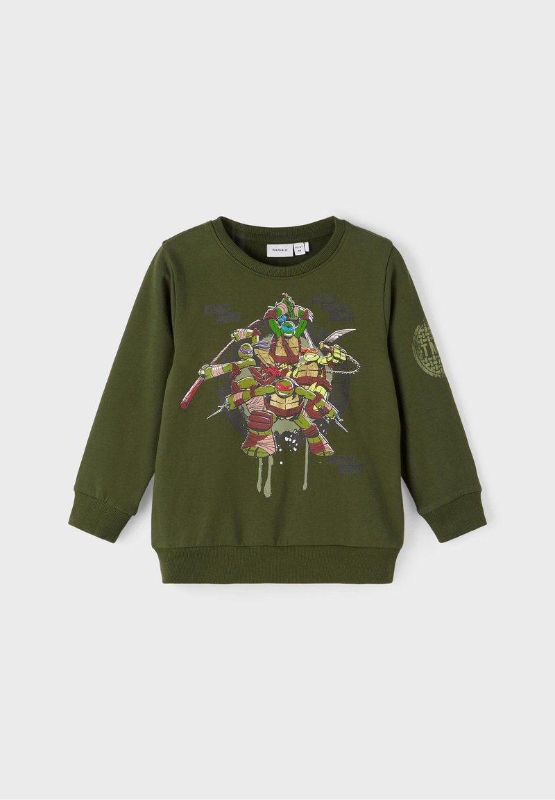 Sweat-shirt vert à manches longues pour enfants, avec quatre Tortues Ninja en pleine action sur le devant et un emblème circulaire sur la manche.