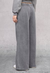 Grijze, wijde sweatpants gemaakt van zachte stof. Beschikt over een elastische tailleband en versterkte stiksels. Geen zichtbare zakken.