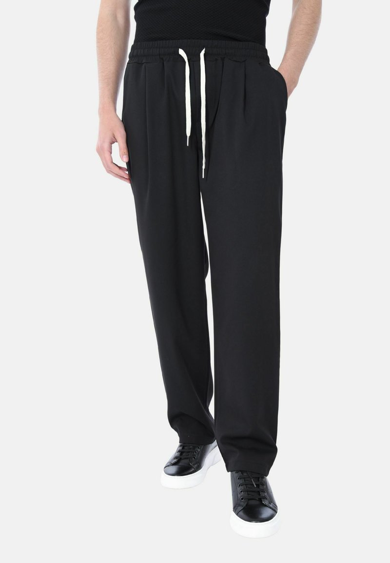 Pantaloni jogger neri realizzati in un tessuto morbido, con una vita elastica con cordoncini, tasche frontali e una vestibilità comoda.
