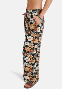 Floral print wide-leg pants in black, featuring brown and cream flowers, side pockets, and a comfortable elastic waistband.