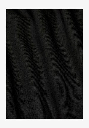 Schwarzer Stoff mit subtiler diagonaler Rippstruktur und kleinen erhabenen Punkten, zeigt sanfte Falten und leichte Schatten.