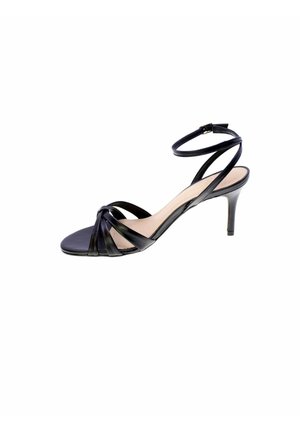 Sandalo nero con cinturini, punta aperta, tacco a spillo di altezza media e fibbia alla caviglia su sfondo bianco semplice.