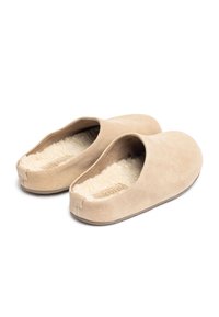 Zapatillas de ante beige con un suave y esponjoso forro interior. Diseño de talón cerrado con una forma de punta redondeada y un estilo minimalista.